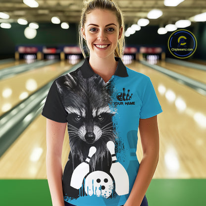 Woman wearing a black and blue raccoon bowling polo shirt at a bowling alley front view.