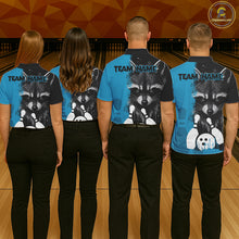 Load image into Gallery viewer, Back view of bowling team wearing matching black and blue raccoon bowling shirts in a bowling alley.