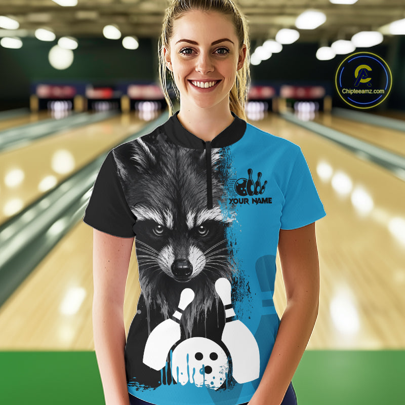 Woman wearing a black and blue raccoon bowling quarter zip jersey during league competition front view.